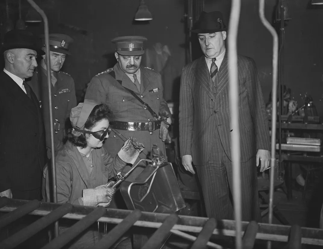The maharaja watches a welder at work during a visit to England in October 1942.