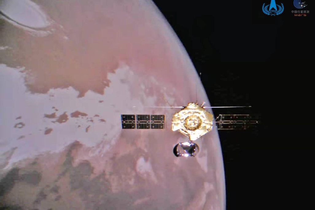 An image of the Tianwen-1 orbiter orbiting above the Martian surface