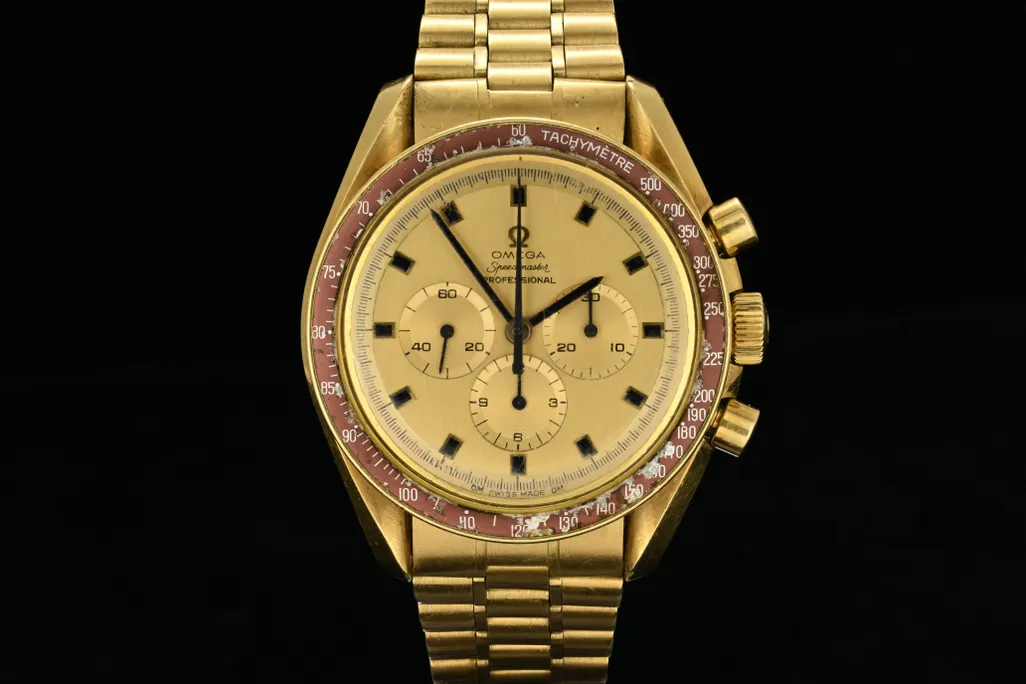 Gold watch against black background