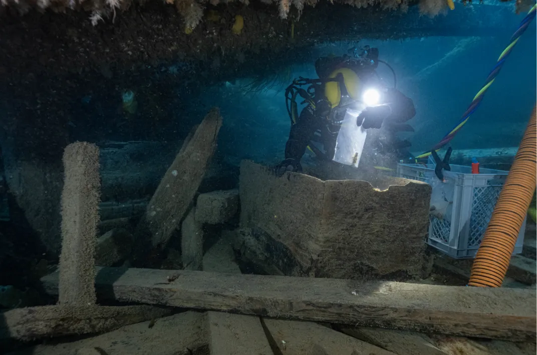 Archaeologist Marc-André Bernier carefully excavates a seamen’s chest in the forecastle (crew living quarters) on the lower deck of HMS Erebus in 2023.