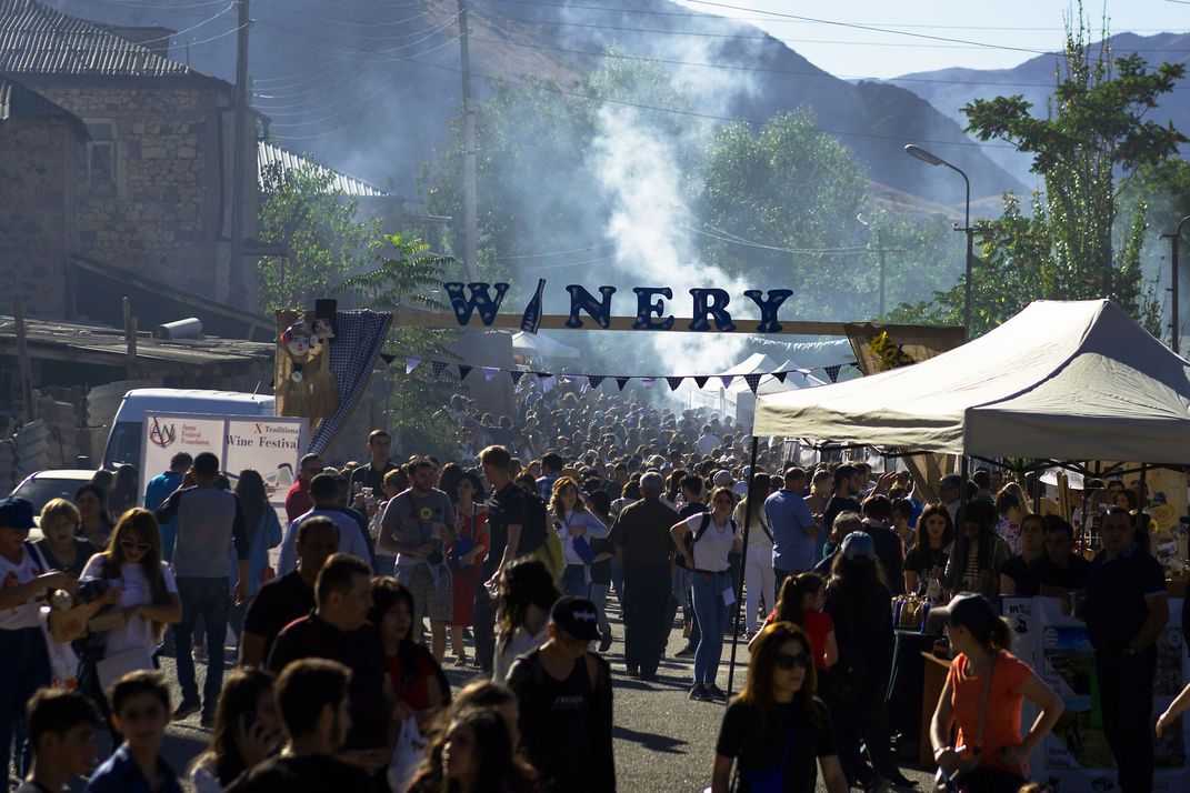 At the Areni Wine Festival, people stand gathered in a large group under a banner reading "winery."