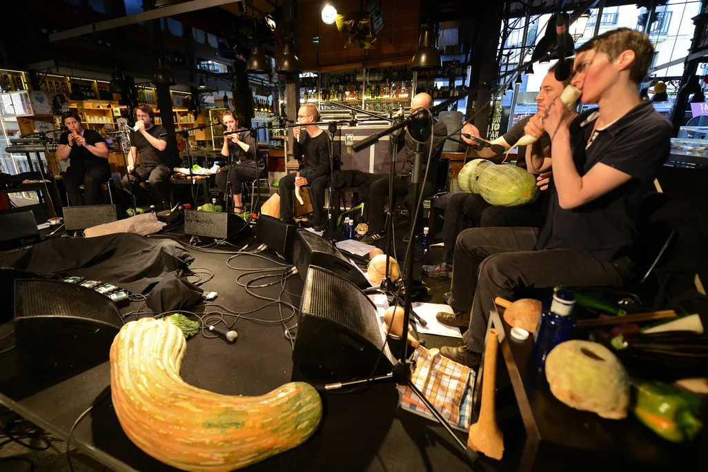 People playing instruments made from vegetables on a stage