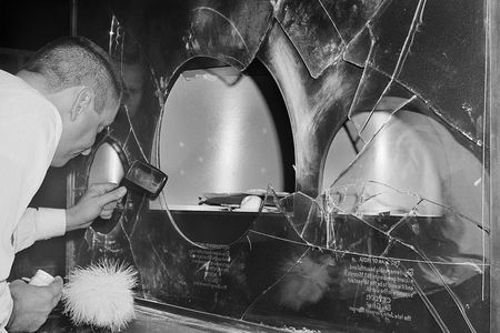 On Oct. 30, 1964, a policeman dusts for fingerprints on case broken into by a cat burglar who made off with some $200,000 in jewels from the Museum of Natural History. 