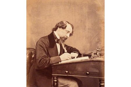 Charles Dickens, seen at his desk in 1858