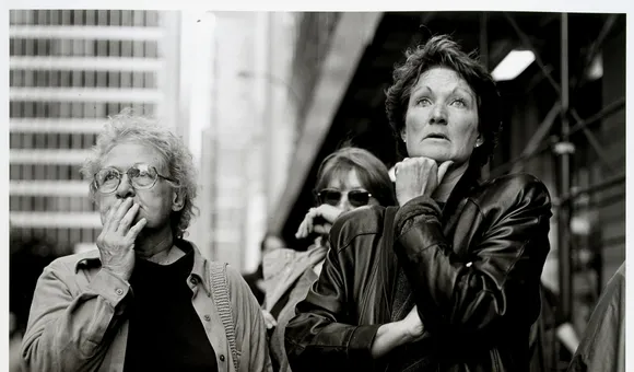 Black and white photograph of people looking at the World Trade Center.