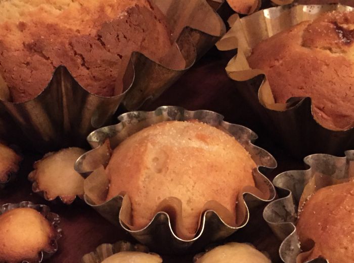 Freshly backed, round, golden brown tortas sit to cool in their crinkled metal baking tins.