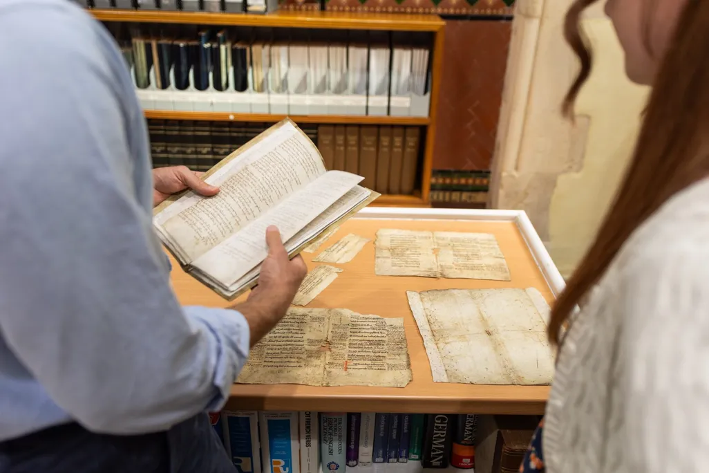 A man and a woman looking at historical documents on a table