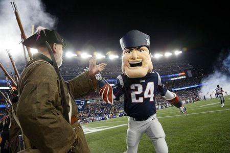 New England Patriots mascot Pat Patriot high-fives a minuteman after an NFL football game against the New York Jets, Oct. 16, 2014.