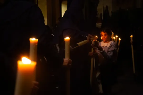 A Young Spanish Girl Collects Candle Wax During Semana Santa thumbnail