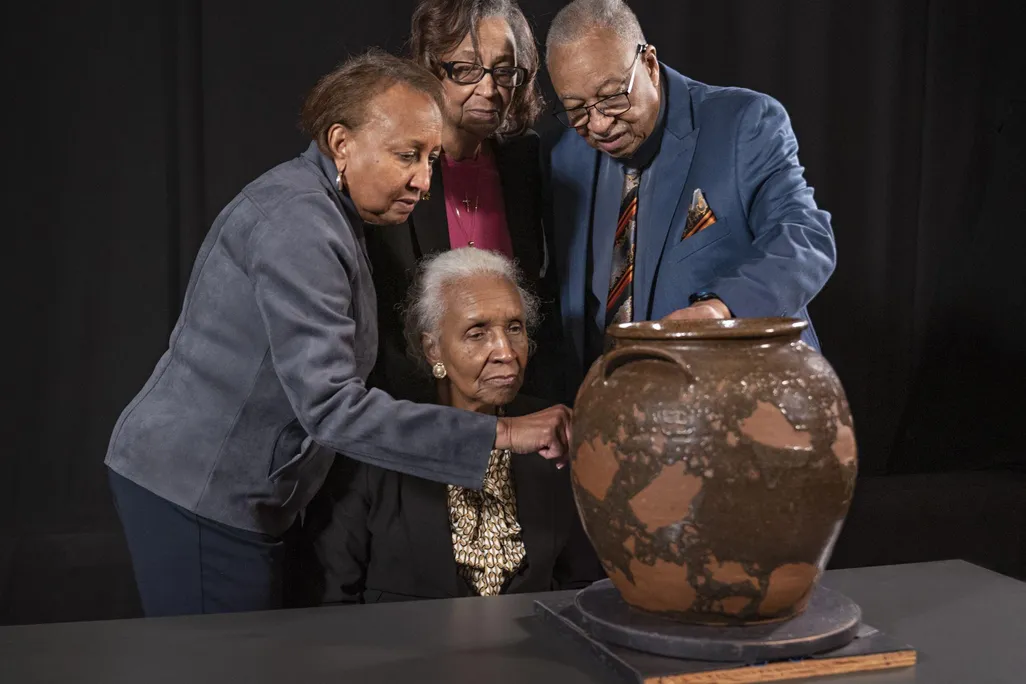 Pauline Baker, Daisy Whitner, John Williams, and Priscilla Williams Carolina, descendants of potter David Drake, with one of the artist’s works.