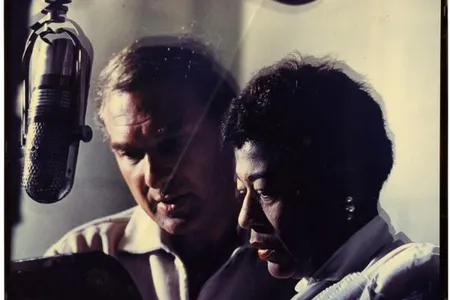 Norman Granz and Ella Fitzgerald at a microphone, 1950.