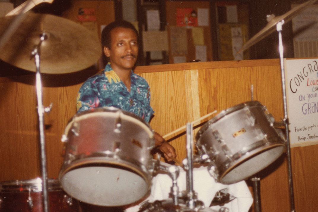 Drummer behind a silver drum kit.