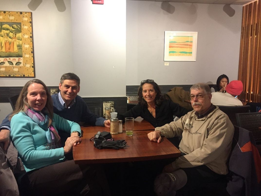 People sitting around an empty table.