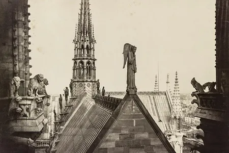 A rooftop view with gargoyles on the left and other statuary, circa 1860.