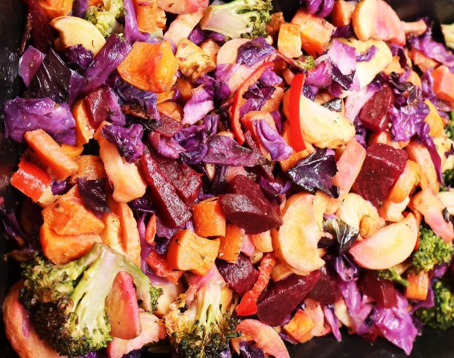 Brightly colored cooked vegetables including carrots, cabbage, potatoes and broccoli