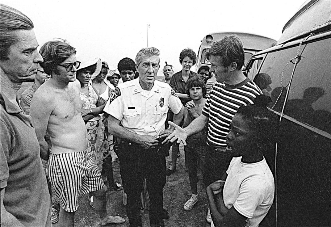 Ned Coll, right, confronted by a local police officer in Madison