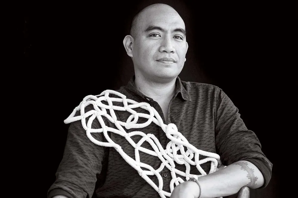 a black and white portrait of a man sitting in a chair