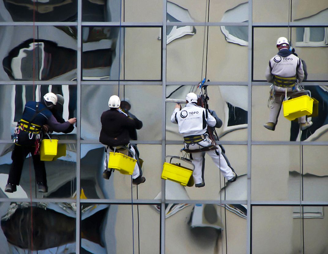 Photo of a window washers washing the windows of a building