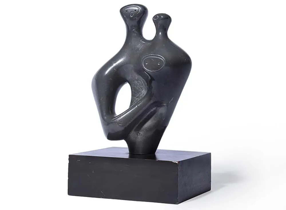 abstract lead statue of two humanlike figures embracing
