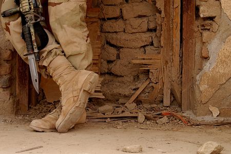 A member of the U.S. Army 3/187th Scouts from Fort Campbell, Kentucky, takes a break at a bombed out building on April 12, 2002, at Kandahar Air Base, Afghanistan.
 