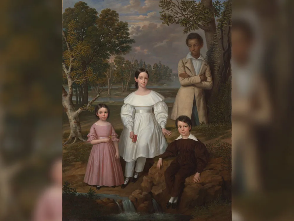 Portrait of three white children with Black teenager standing behind