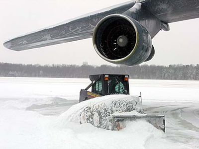 A member of the 436th Aircraft Maintenance Squadron clears the snow around a C-5 Galaxy at Dover Air Force Base this morning.  Five inches of snow fell overnight, and freezing rain followed by more snow is expected over the next 24 hours. (Photo by Lt. Col. Jon Anderson)