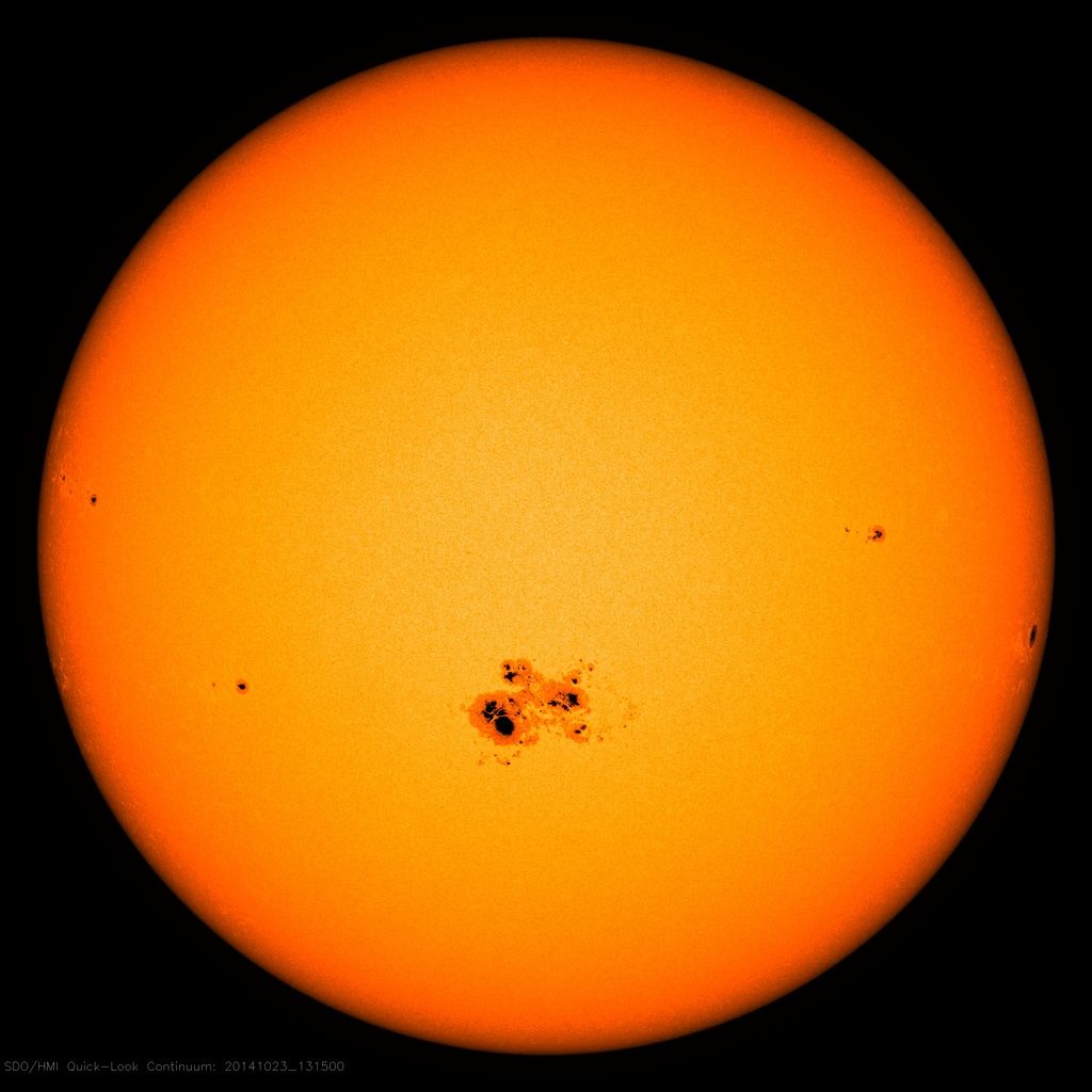 The sun with dark sunspots just below its center