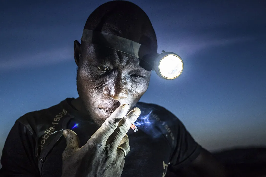 An African man with a headlamp at night