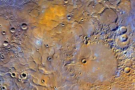 Mercury’s northern volcanic plains shown in enhanced color to emphasize rocks types. The bottom left portion of the image displays large wrinkle ridges, formed during lava cooling. Near the top of the image, a bright orange region shows the location of a volcanic vent.
