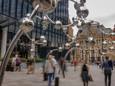 Commuters pass by Yayoi Kusama&#39;s new public sculpture,&nbsp;Infinite Accumulation, at Liverpool Street station in London.