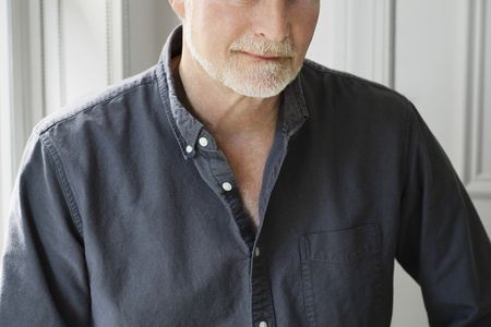 A portrait of a man wearing a dark shirt
