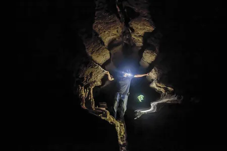 Dr. Maxime Aubert, archeologist and geochemist, uses his headlamp to examine the cave art at Leang Lompoa in Maros, Indonesia.
