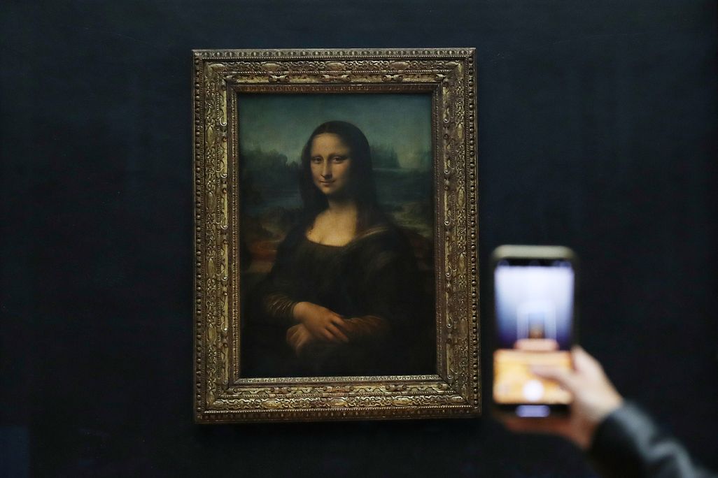 Visitor takes a photo of the Mona Lisa