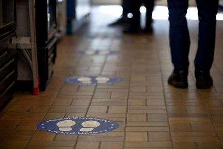 Signs on the floor encourage social distancing.