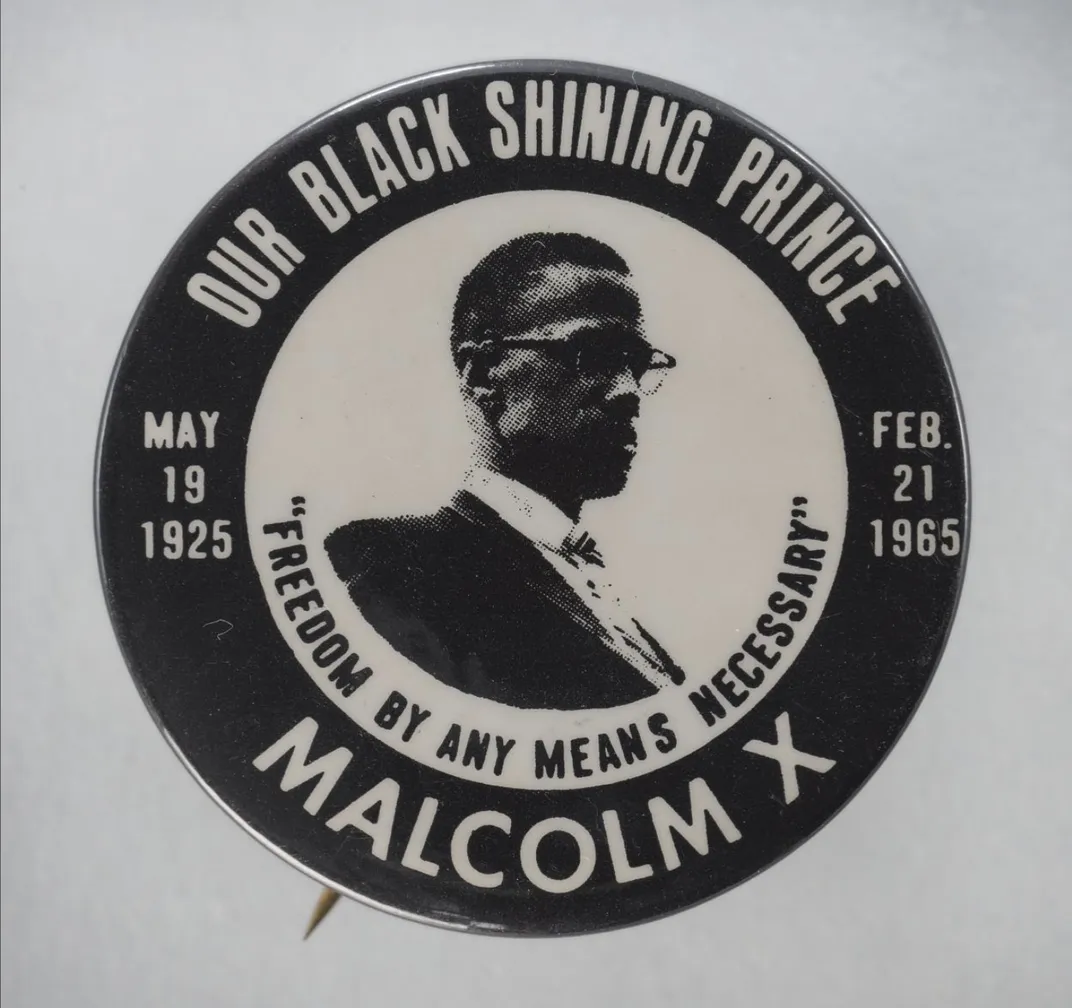 A black and white button with Malcolm's likeness that reads "Our Black Shining Prince" and "Freedom by any means necessary"