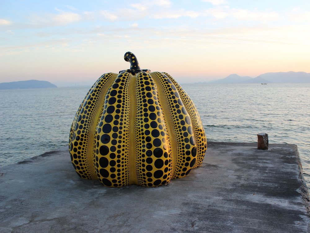 Yayoi Kusama Pumpkin sculpture on a pier