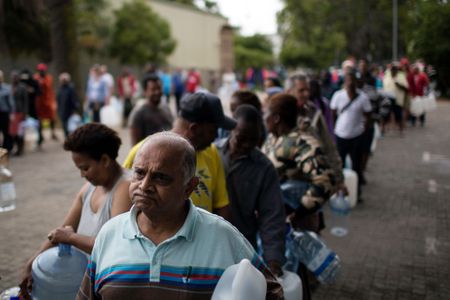 Residents queue to fill containers with water from a source of natural spring water in Cape Town, South Africa, Friday, Feb. 2, 2018.