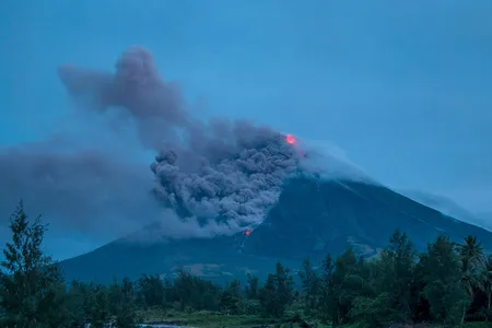 Lava cascades down the slopes of the erupting Mayon volcano in January 2018. Seen from Busay Village in Albay province, 210 miles southeast of Manila, Philippines.