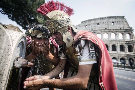 Centurions drink from a fountain near Rome's Coliseum during a heat wave in summer 2014. A recent announcement that centurion reenactors will be banned from the Coliseum during 2016 has led to protests and public outcry.