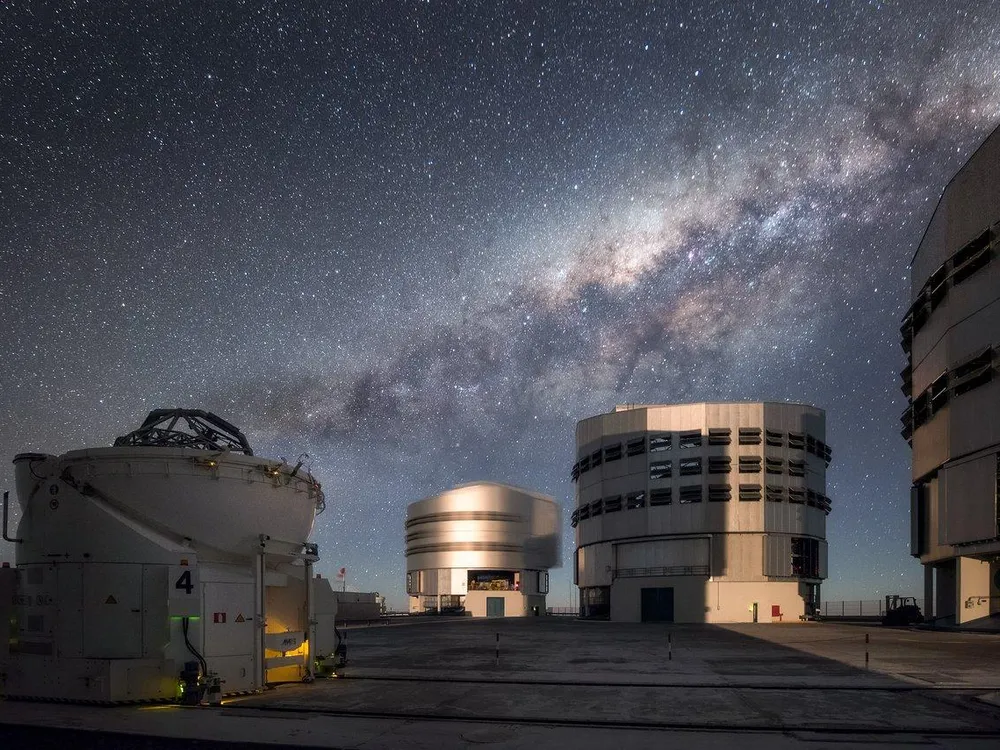 Three of the Very Large Telescope's buildings underneath the Milky Way at night