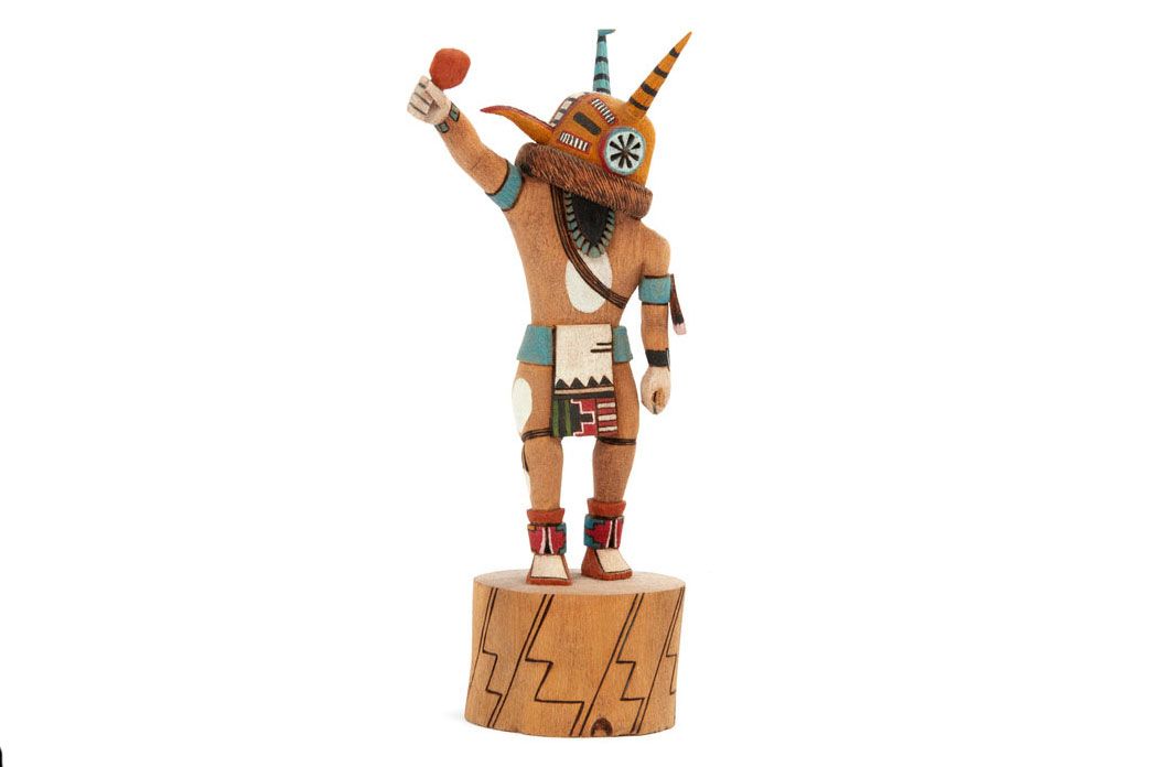 Statuette of a humanoid figure with a sash around the chest, striped conical antennae, and red, turquoise, and white adornments.