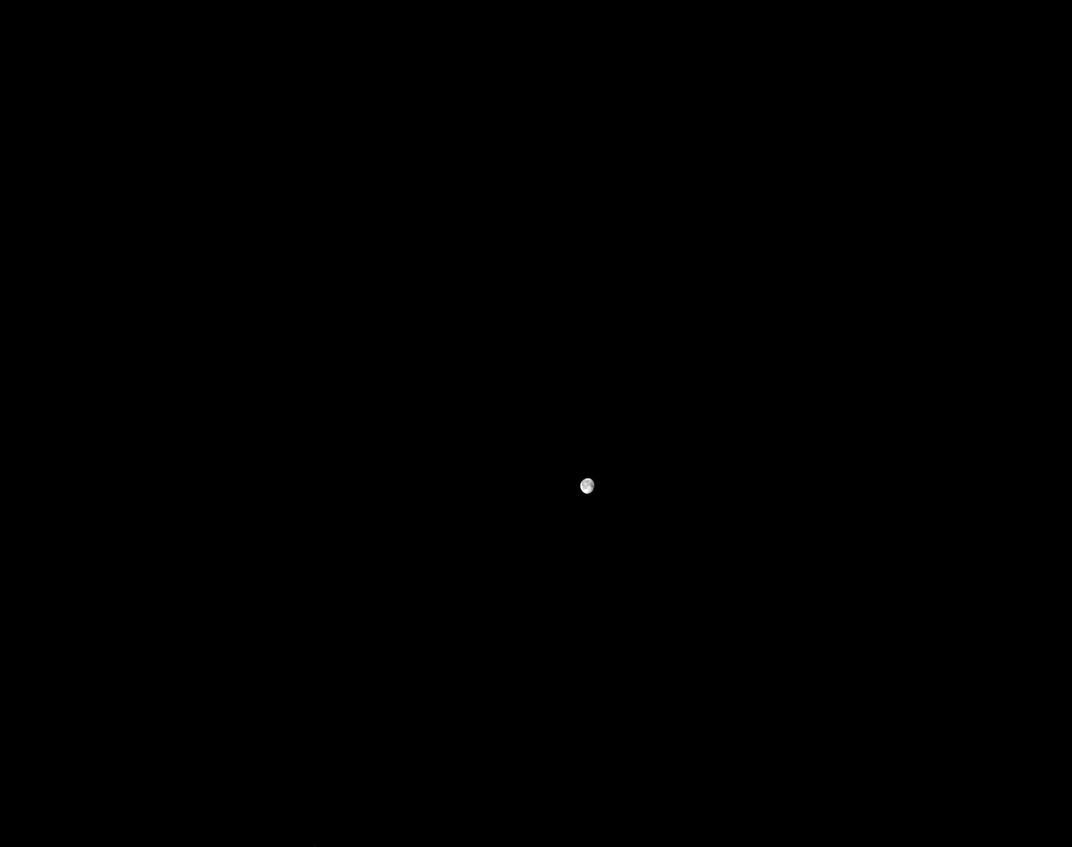 the moon is visible as a tiny white speck amid the darkness of space