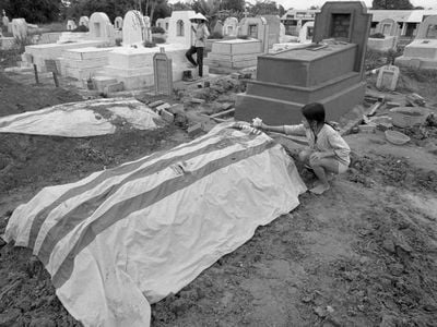 A girl in Vietnam puts flowers on her father’s grave in 1972
