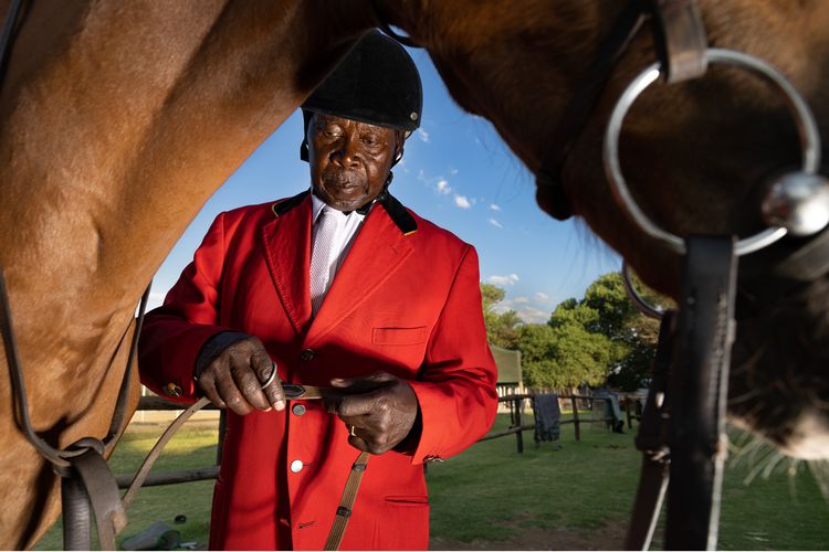 Enos Mafokate holds reins next to a horse