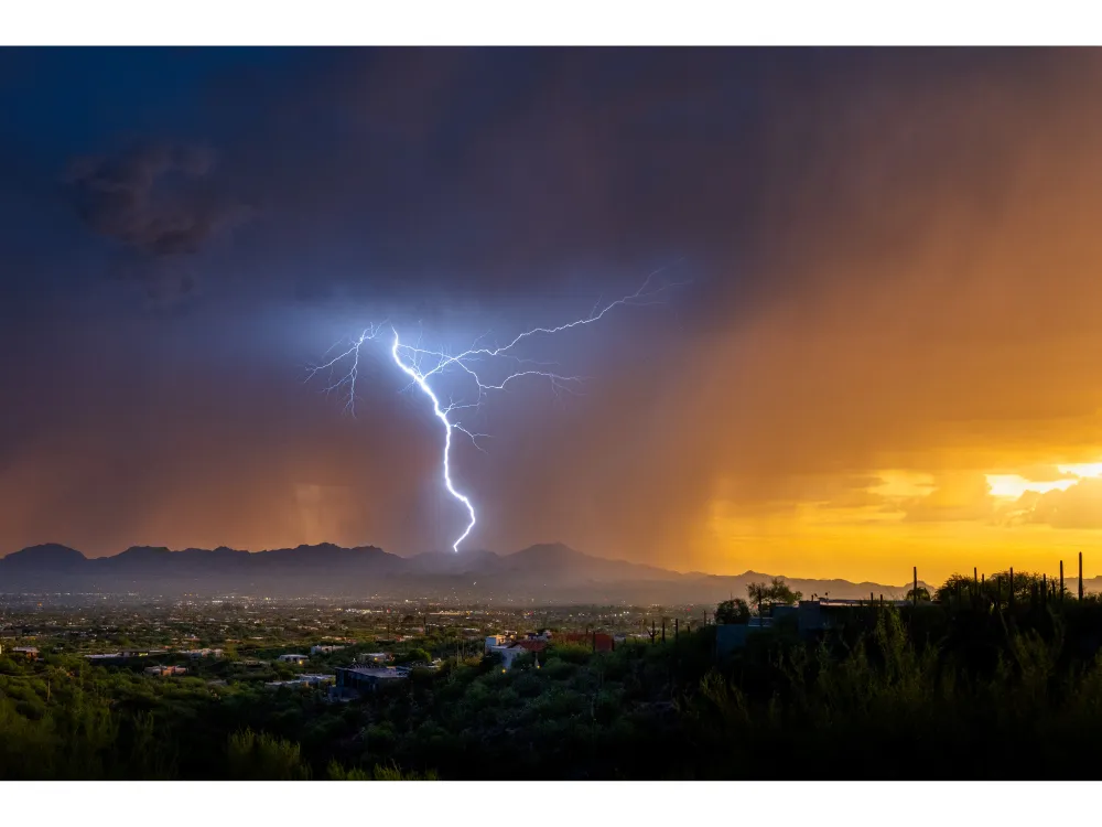 OPENER - Lightning from a summer monsoonal thunderstorm strikes in Tucson just as the sun sets.