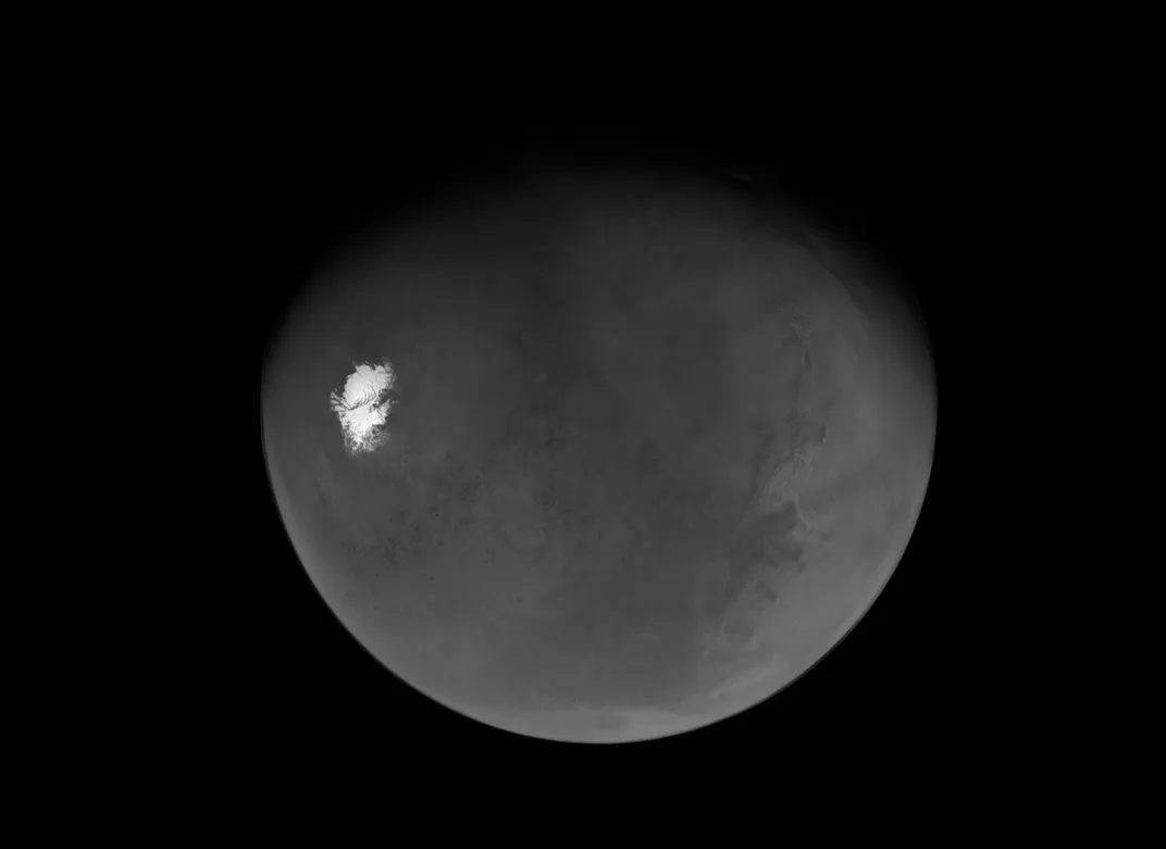 nearly full Mars with a bright spot at the left