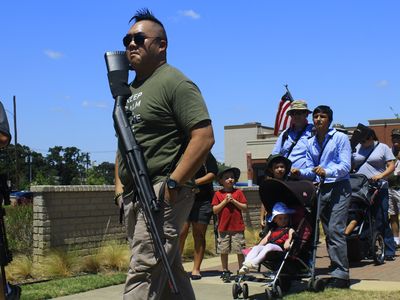 Believing that a large gun presence deters crime and makes Texas safer, almost forty long gun rights activists, slinging long guns over their shoulders and backs, joined in a walking rally calling for less restrictive open carry gun legislation. Arlington, 2013.  
