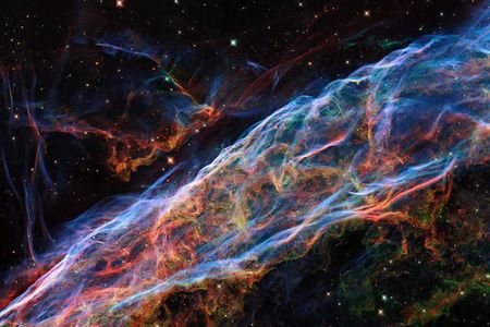 In the new reprocessed image, ionized oxygen is seen in blue and ionized hydrogen and nitrogen glow red. 

