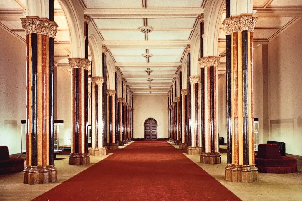 a red carpet surrounded by marble columns