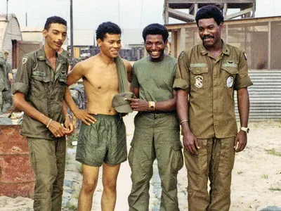 Clyde Romero, James Casher, Eldridge Johnson, and Bob Farris in military green